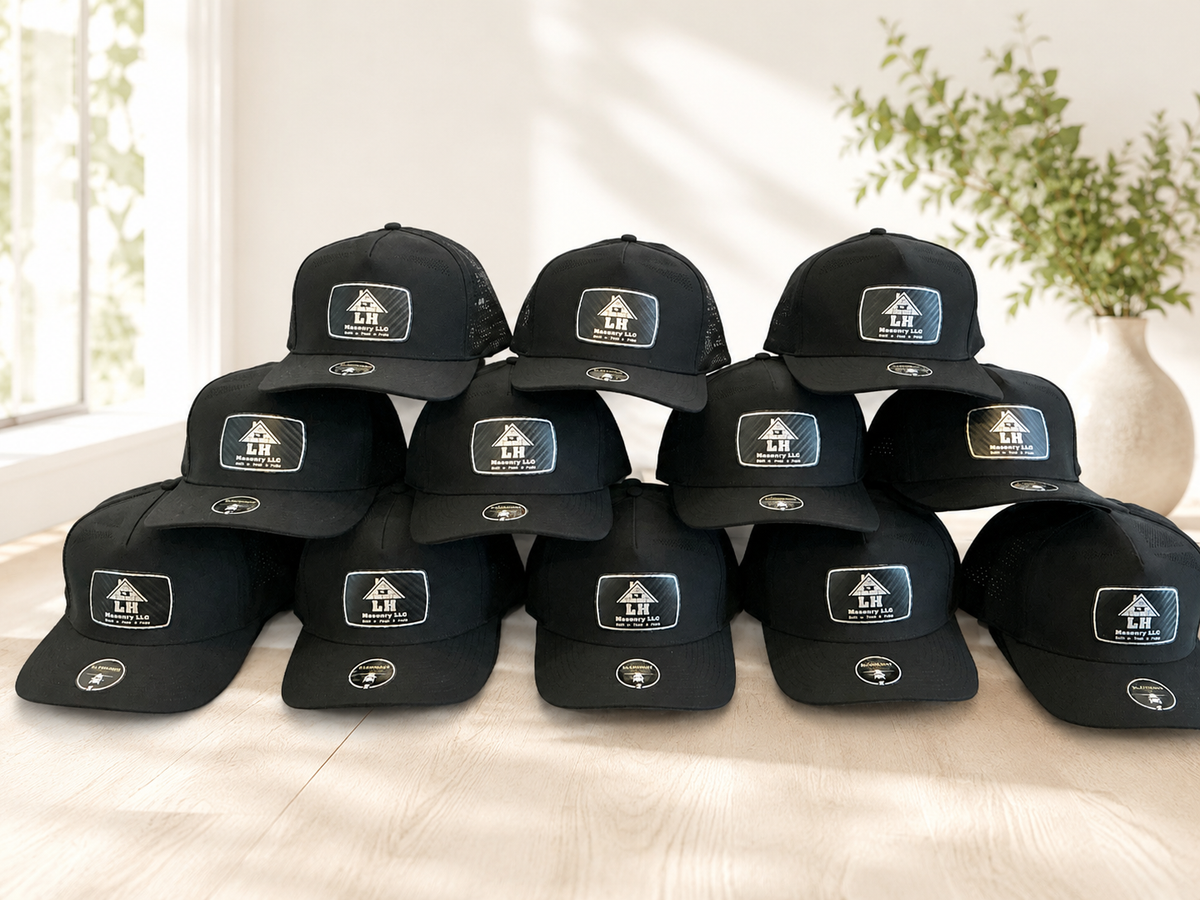 Multiple black caps with logos arranged on a light surface.